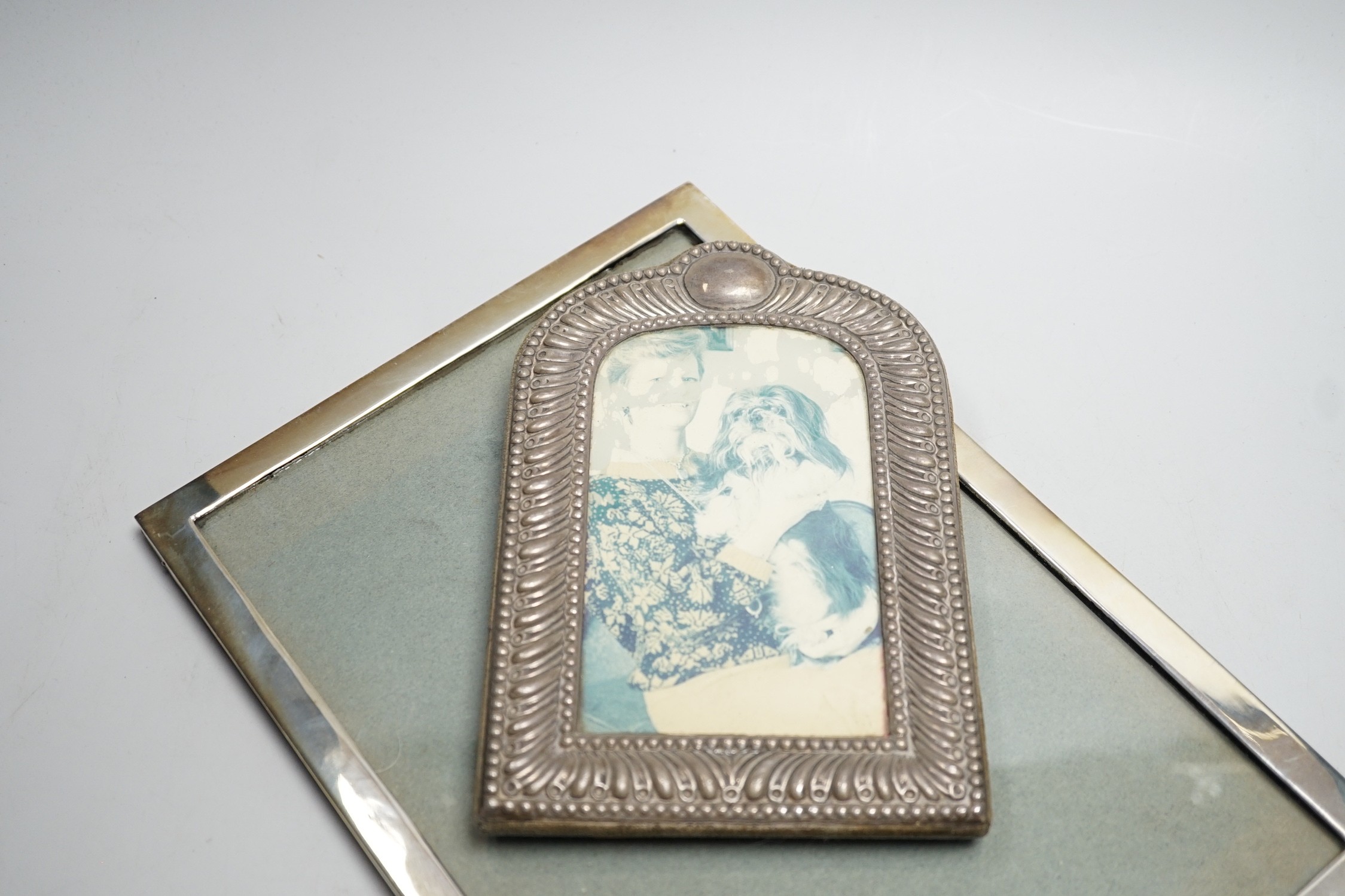 An Edwardian silver mounted rectangular photograph frame, Birmingham, 1908, 30.7cm and a smaller dome topped silver mounted photograph frame.